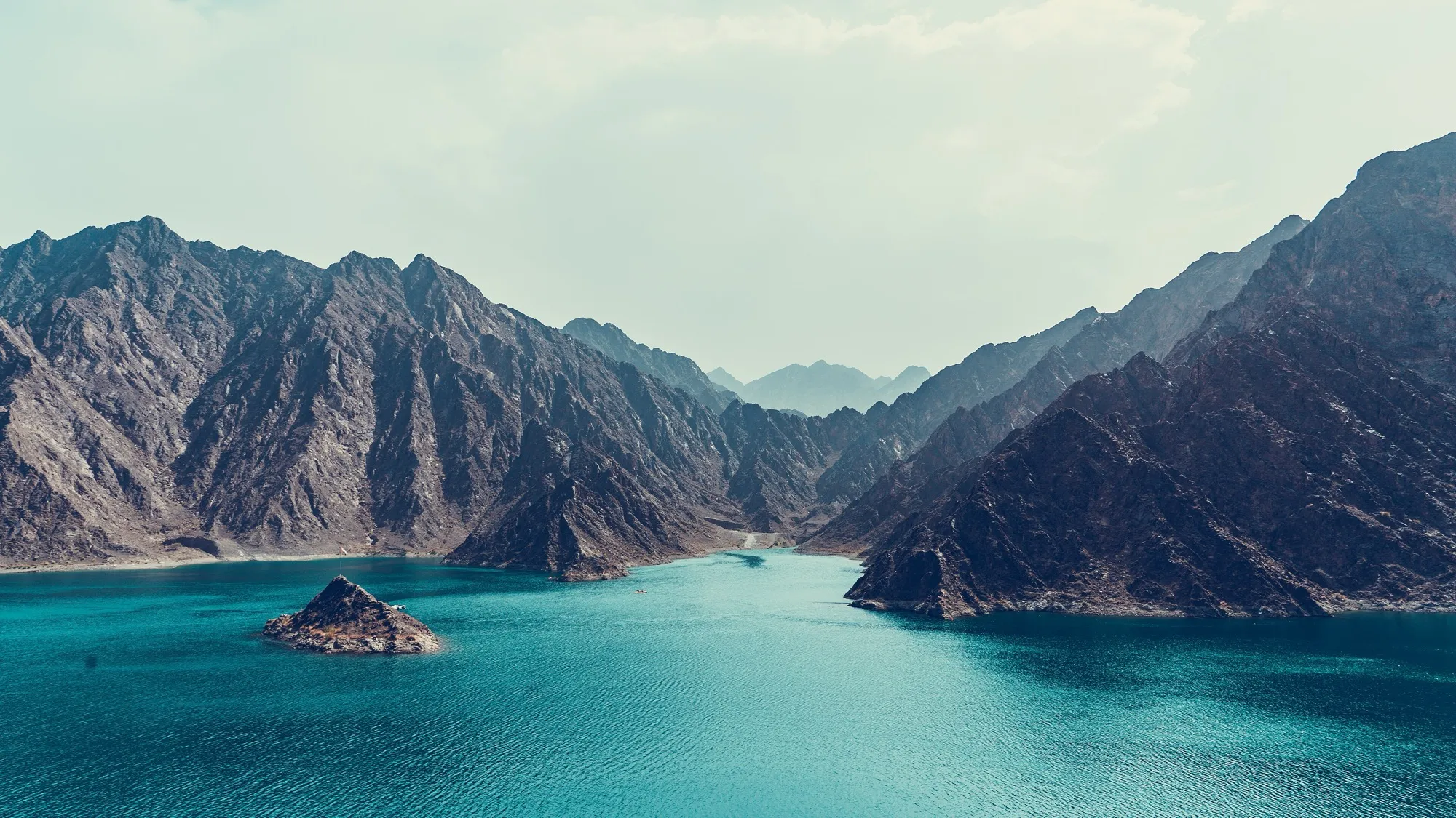 Turquoise water of Hatta Dam between steep Hajar Mountains