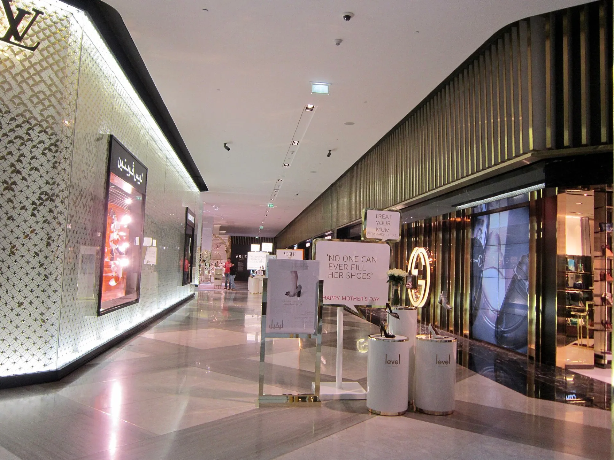 A marble-floored corridor of luxury shop fronts inside The Dubai Mall