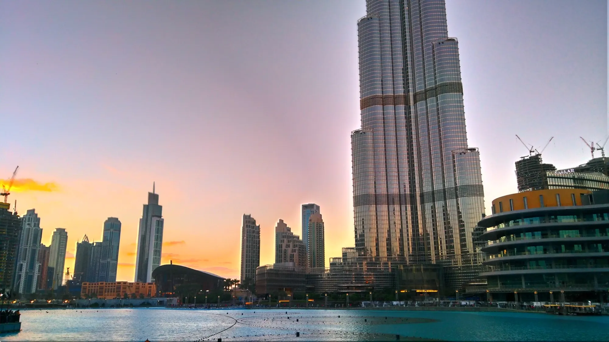 Burj Khalifa rising beside the Dubai Fountain lake in Downtown Dubai at sunset