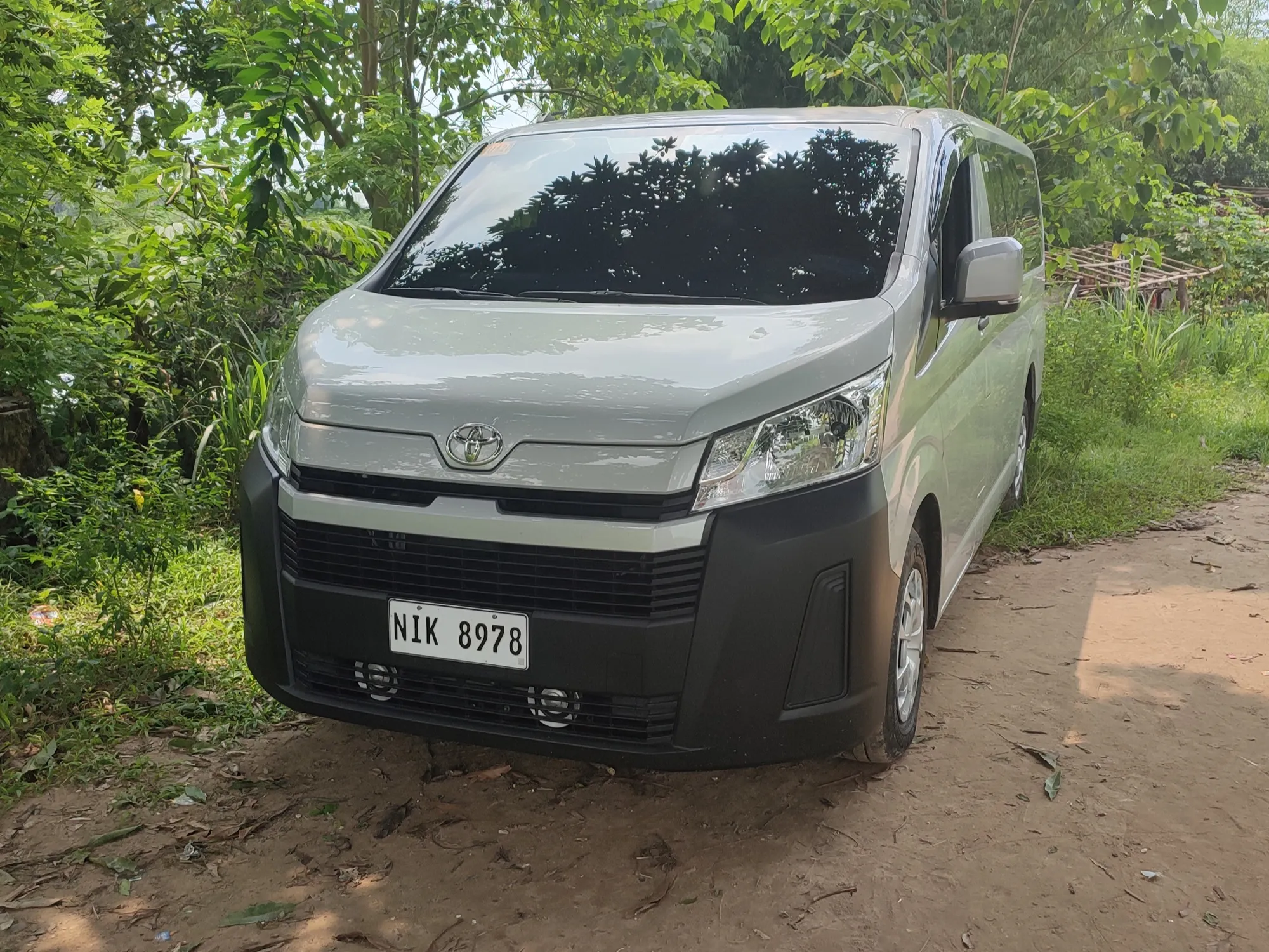A silver Toyota Hiace Commuter passenger van seen from the front