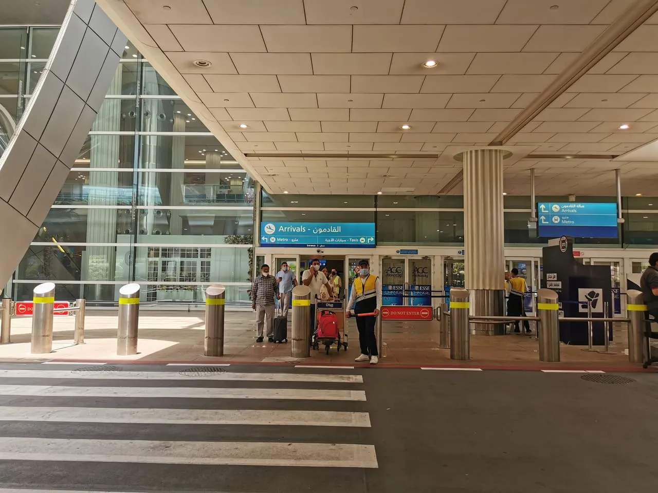 Arrivals exit at Dubai International, with signs to the metro and taxis