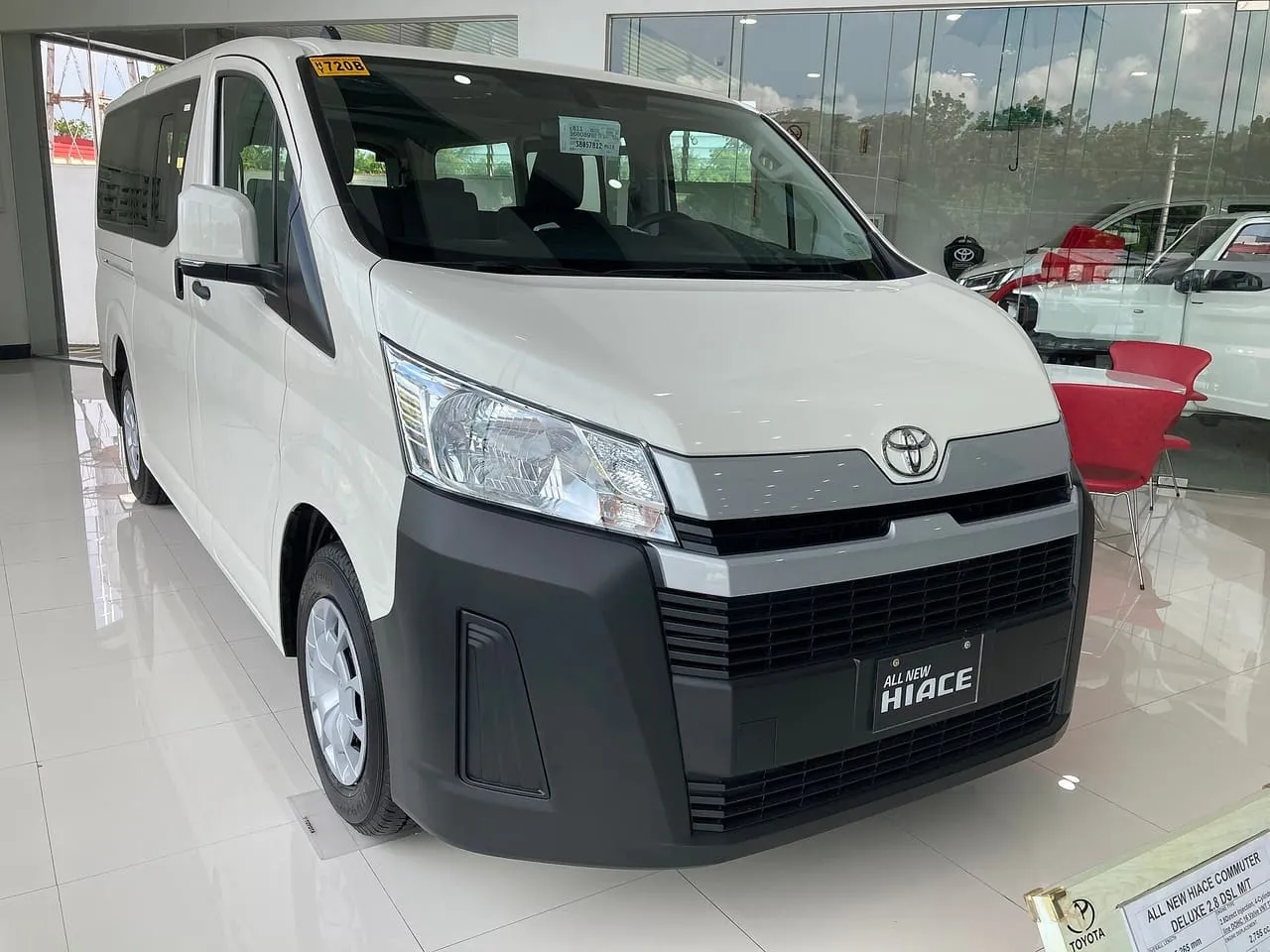 A white Toyota Hiace Commuter van on a showroom floor
