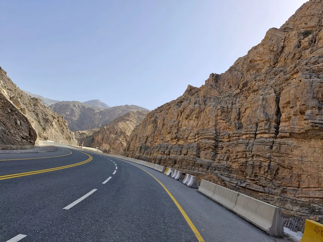 The paved Jebel Jais road curving between rock walls in the Ras Al Khaimah mountains