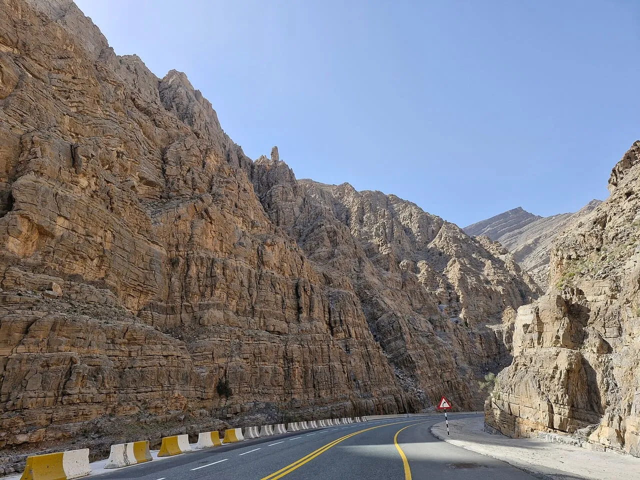 The mountain road to Jebel Jais curving between rock cliffs in Ras Al Khaimah