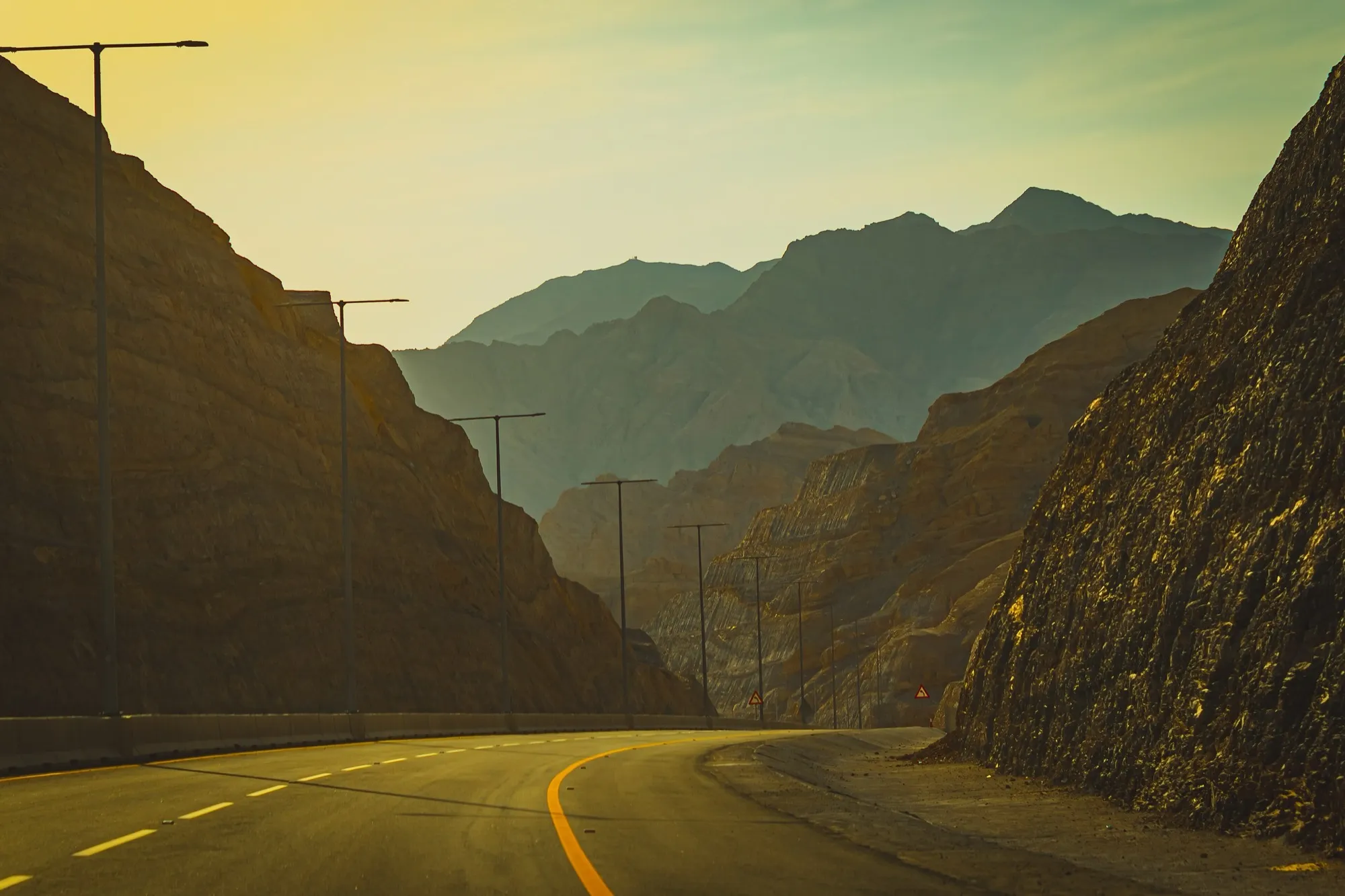 A curving mountain road cut through rock on the way to Jebel Jais, Ras Al Khaimah