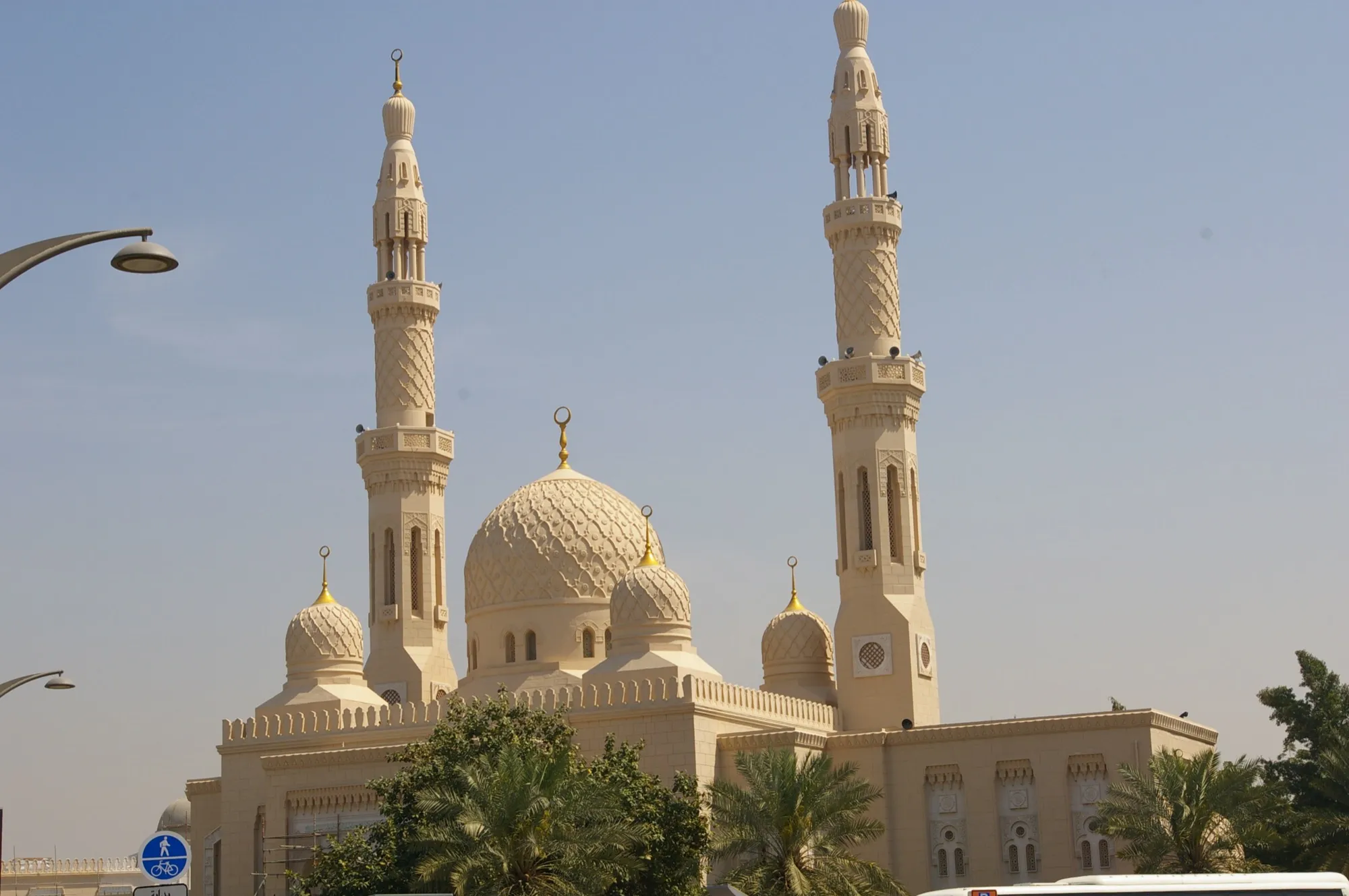 Jumeirah Mosque in Dubai, with two tall minarets and a carved dome under a clear sky