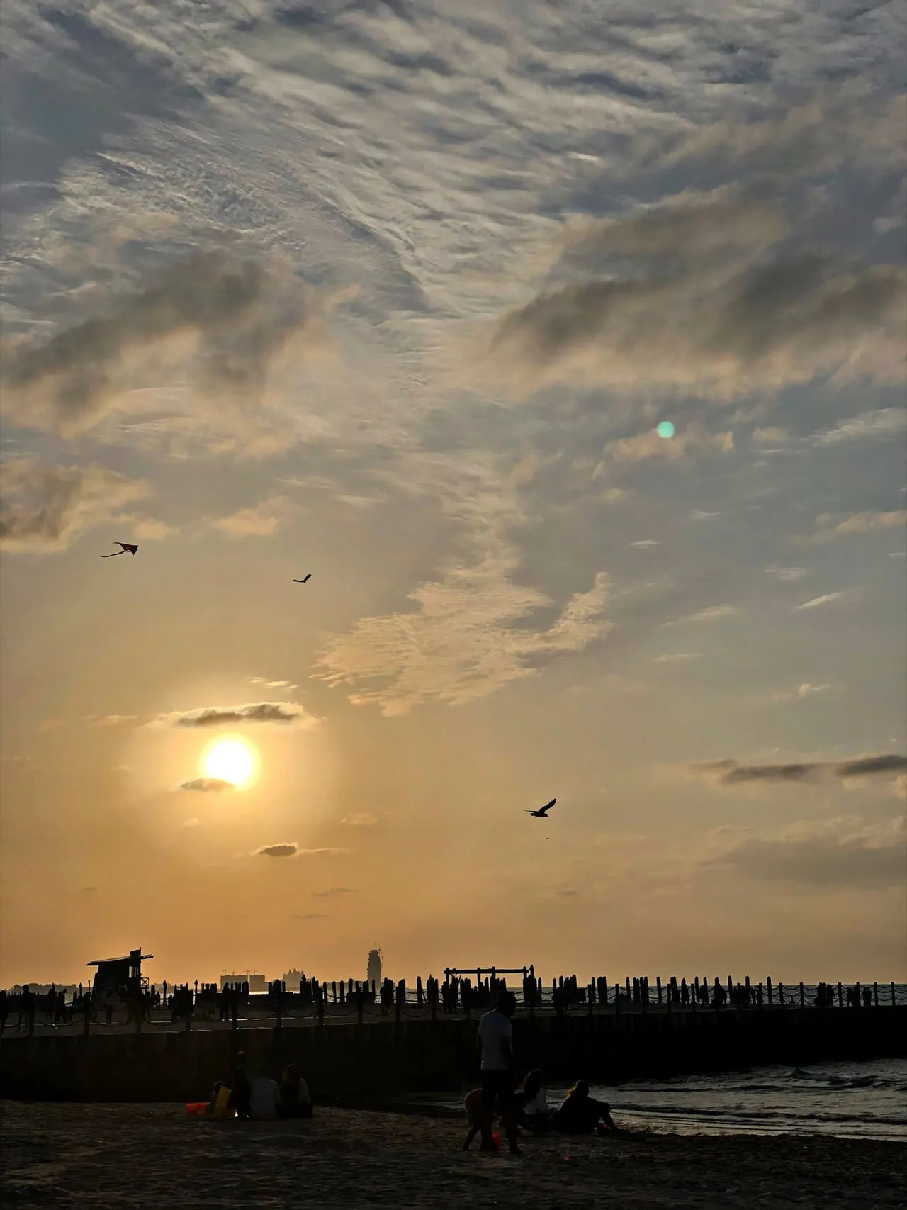 The sun setting over Kite Beach in Dubai, with a lifeguard tower on the sand
