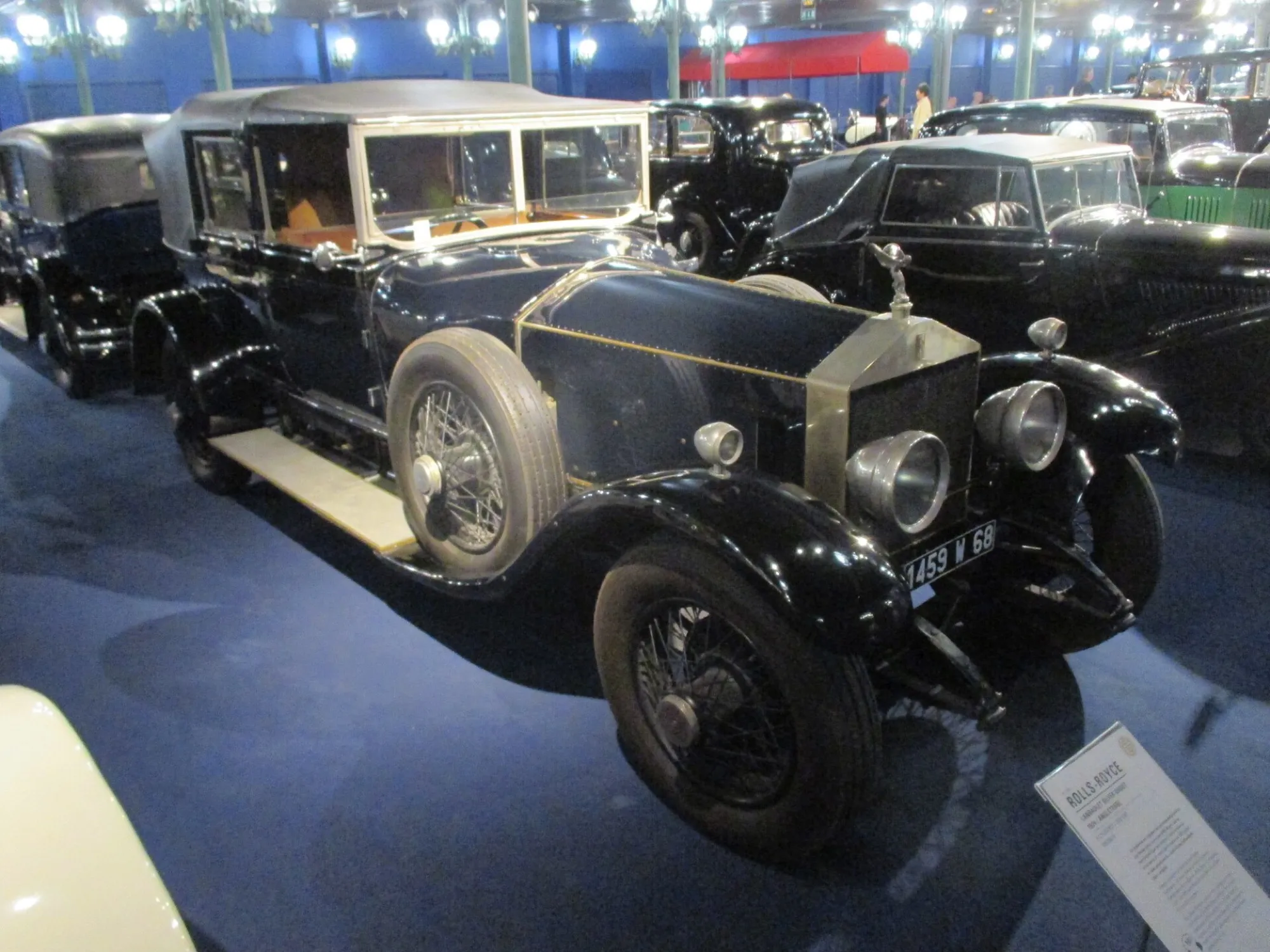 A black 1924 Rolls-Royce Silver Ghost landaulet with a folding hood, on display in a museum hall
