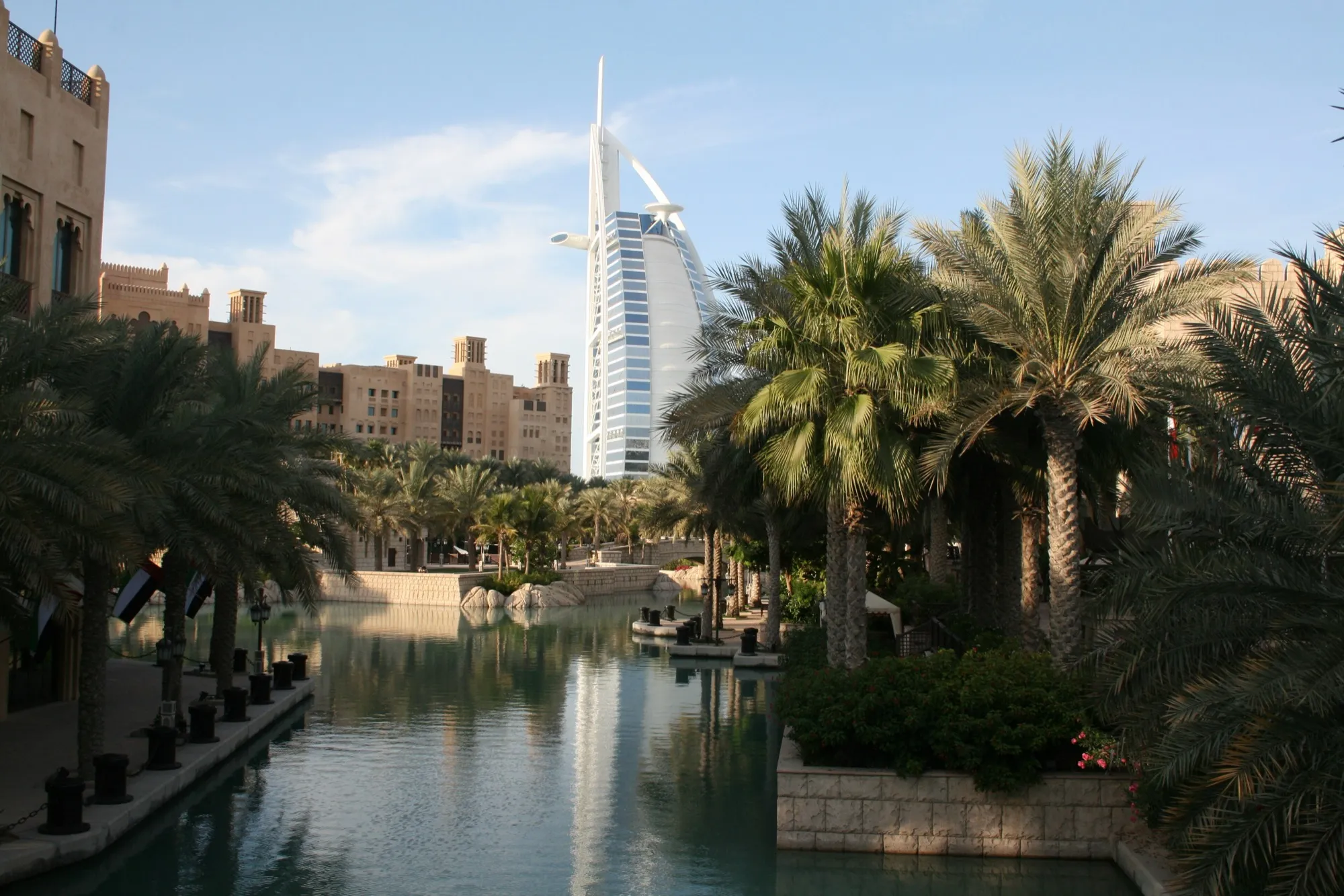A canal at Madinat Jumeirah lined with palms, with the Burj Al Arab behind