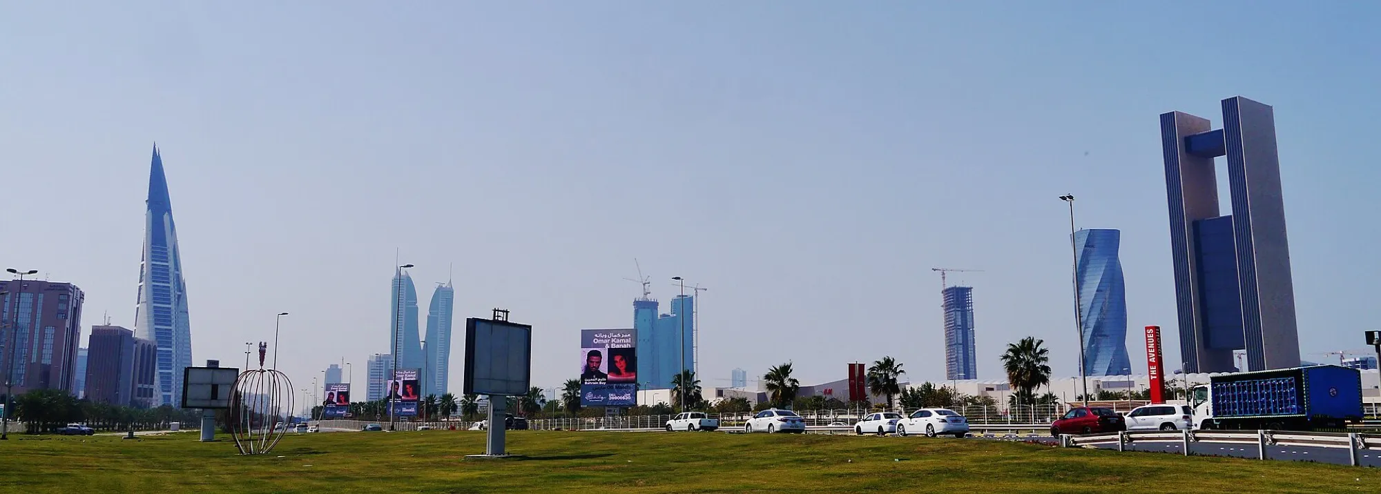 Manama’s skyline with the Bahrain World Trade Center, seen from a roadside lawn