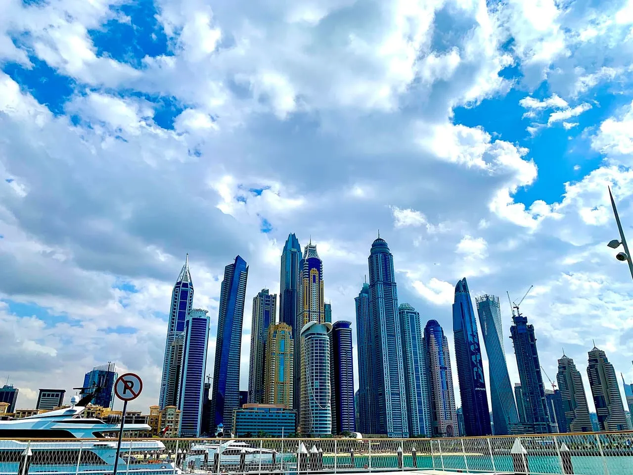 Dubai Marina towers and moored yachts seen from the Dubai Harbour waterfront