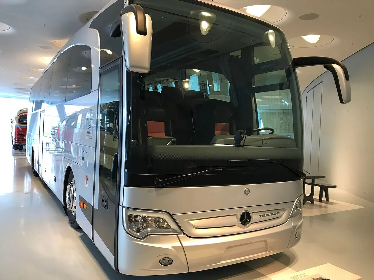 A silver Mercedes-Benz Travego touring coach with tinted windows, seen from the front