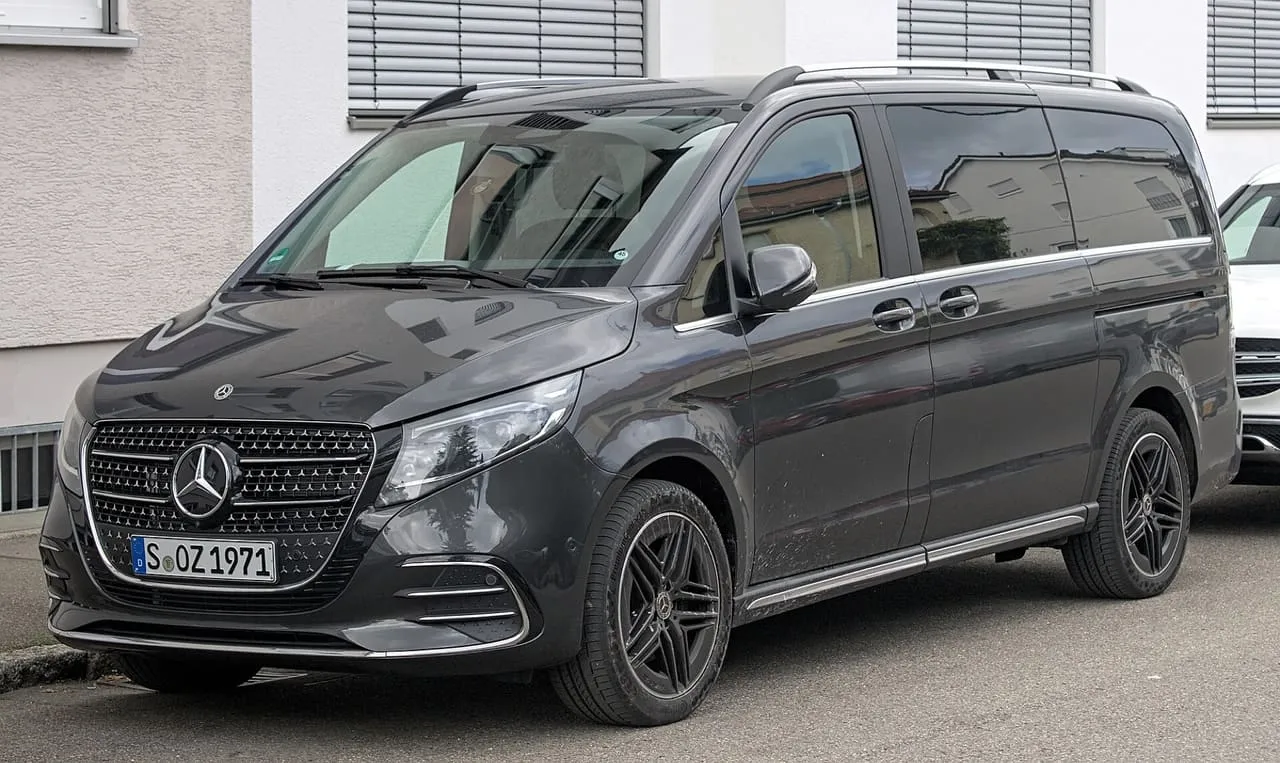 A dark grey Mercedes-Benz V-Class with a sliding side door, parked on a street