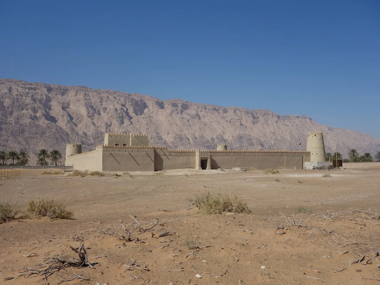 Mezyad Fort in the desert south of Al Ain, with Jebel Hafeet rising behind it