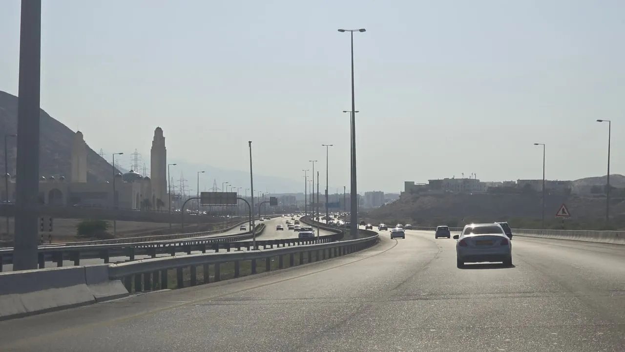 Traffic on the six-lane Muscat Expressway in Oman, with rocky hills beside the road