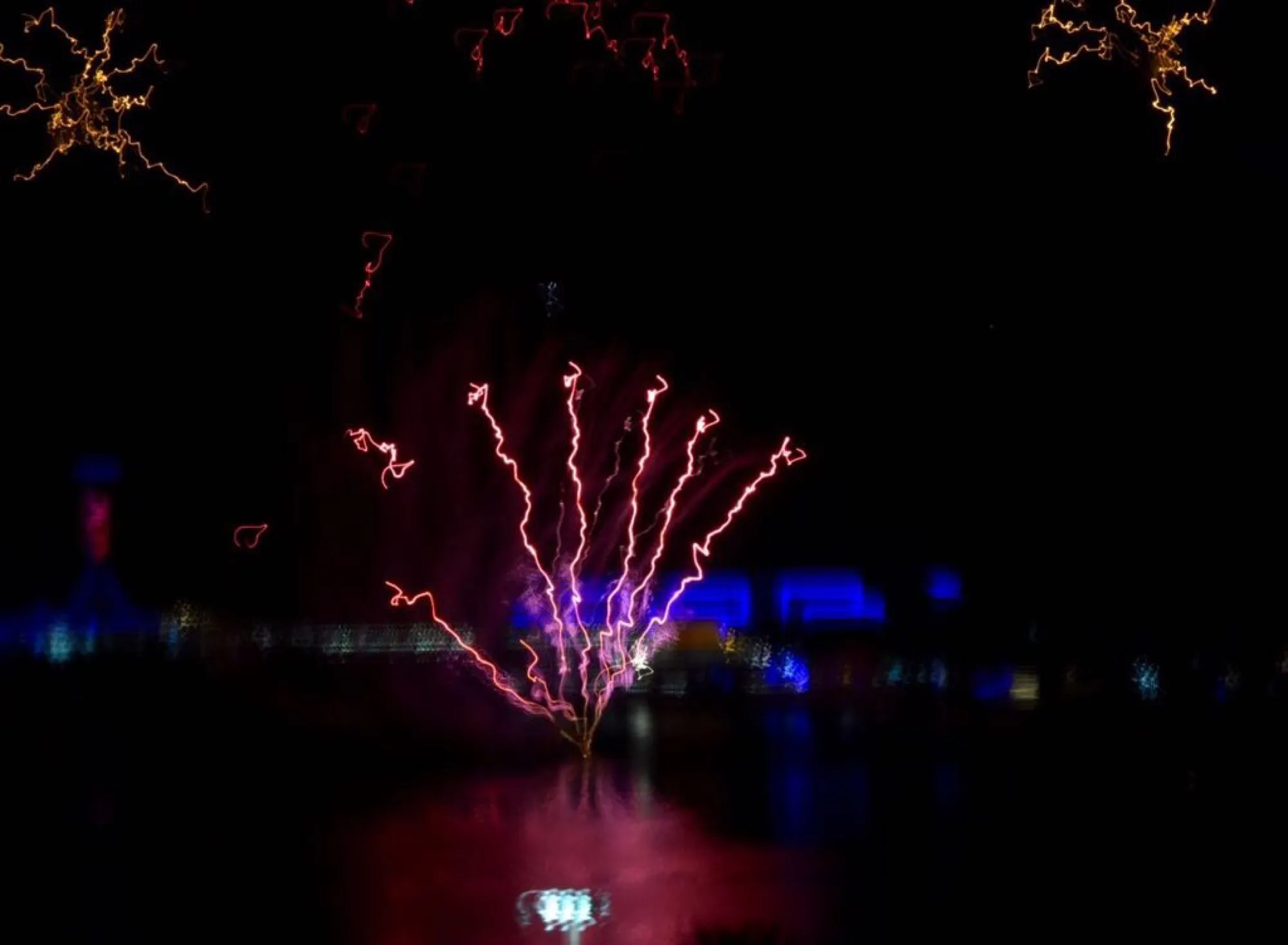 Long-exposure trails of a fireworks display over the water on UAE National Day