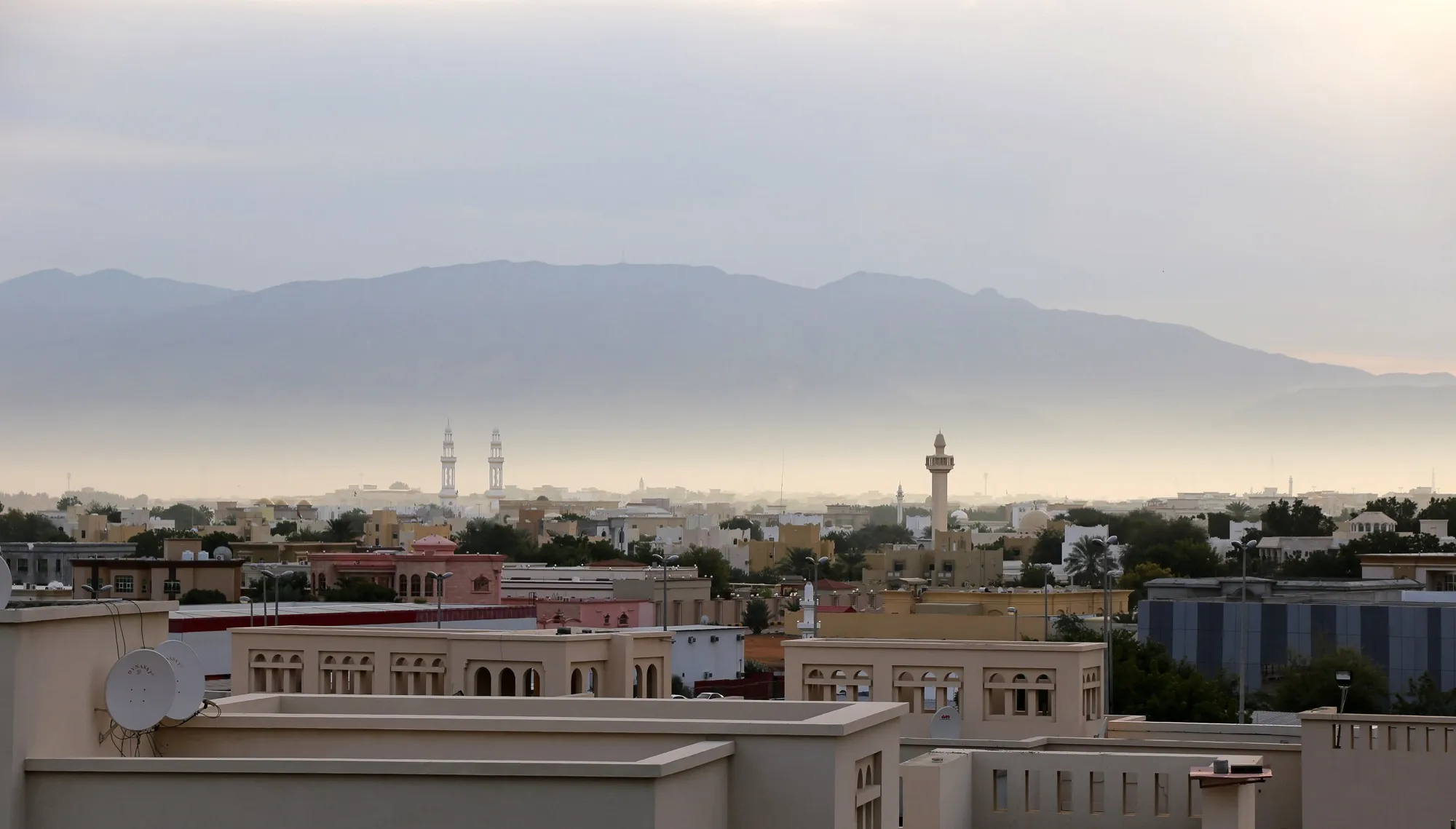 Rooftops and minarets of Ras Al Khaimah with the Hajar mountains behind