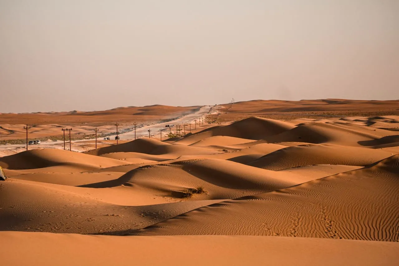 Rolling orange dunes beside a desert road in the Razeen desert, Abu Dhabi emirate