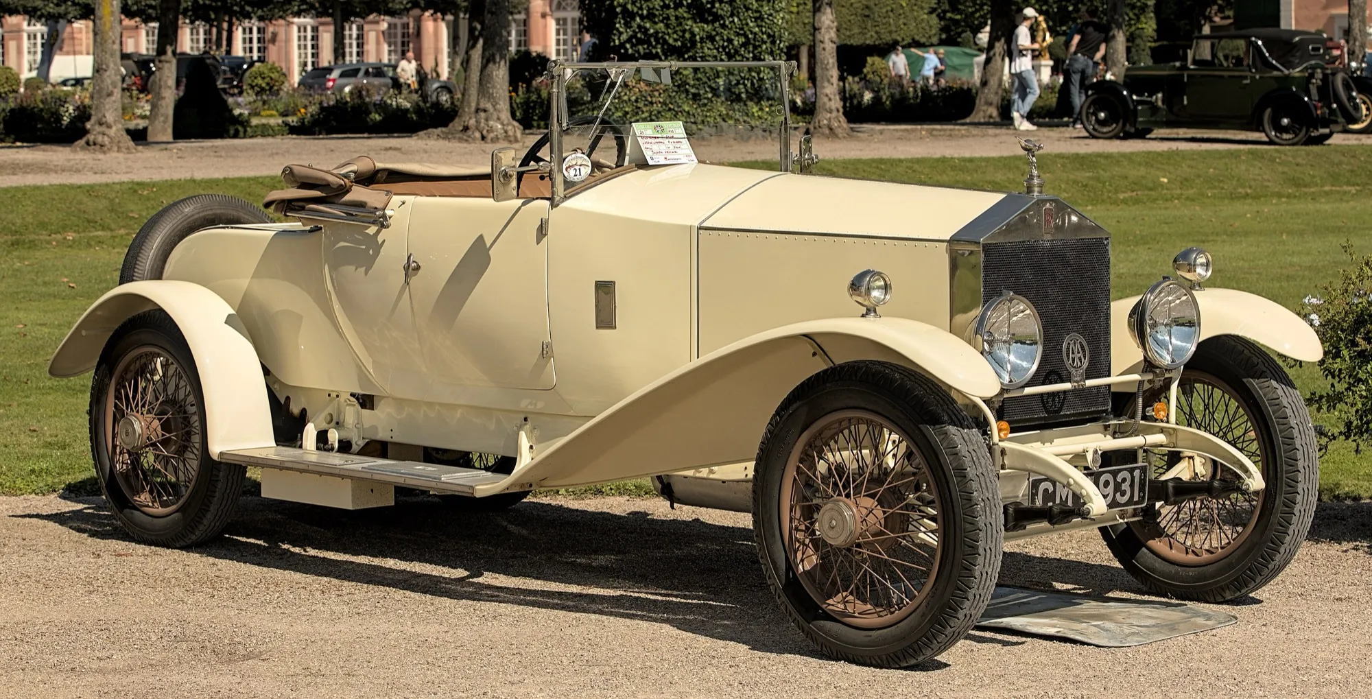 A cream 1923 Rolls-Royce Silver Ghost roadster with wire wheels on a gravel drive