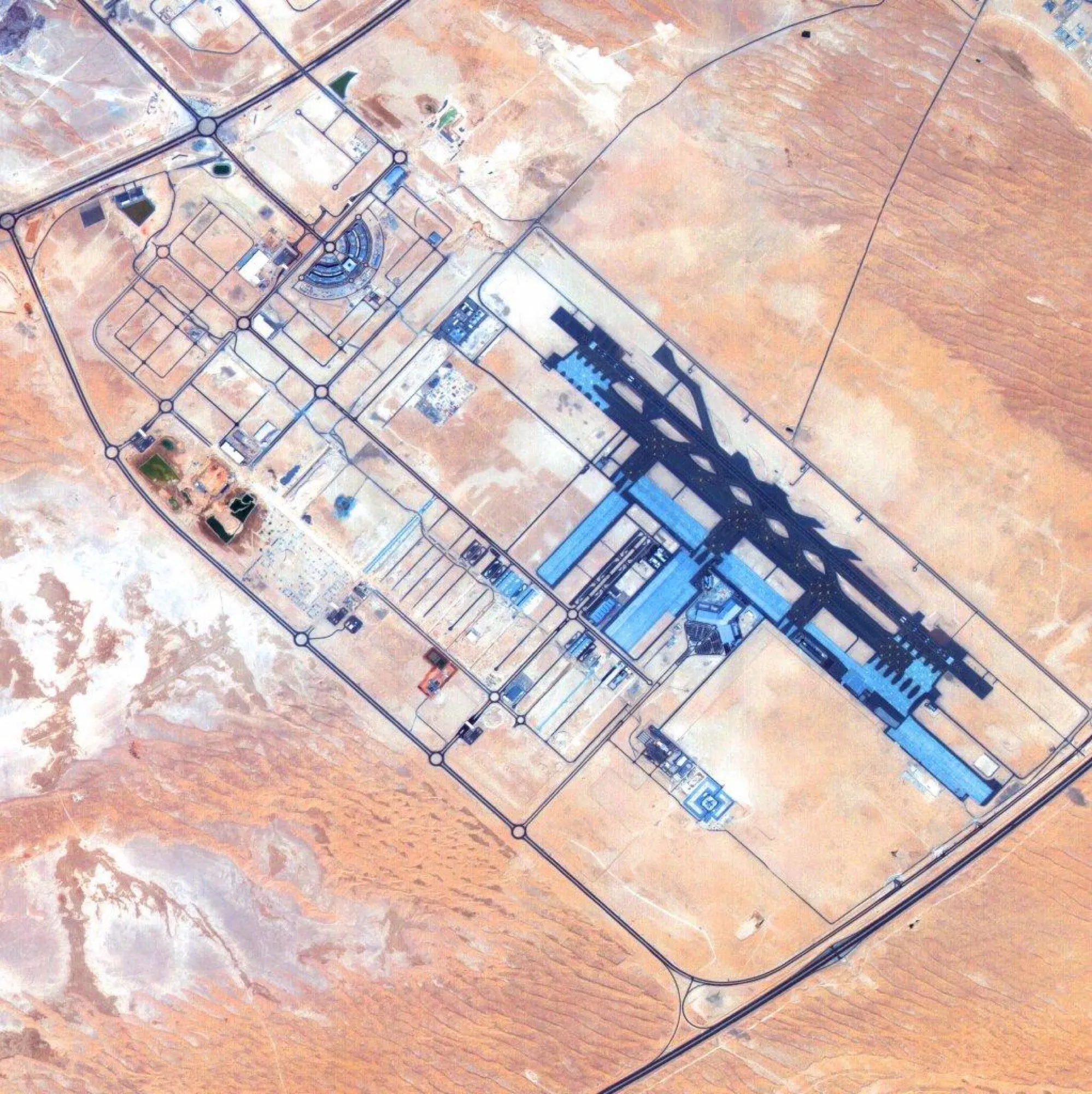 Satellite image of Al Maktoum International Airport, with its runway and apron in the desert south-west of Dubai