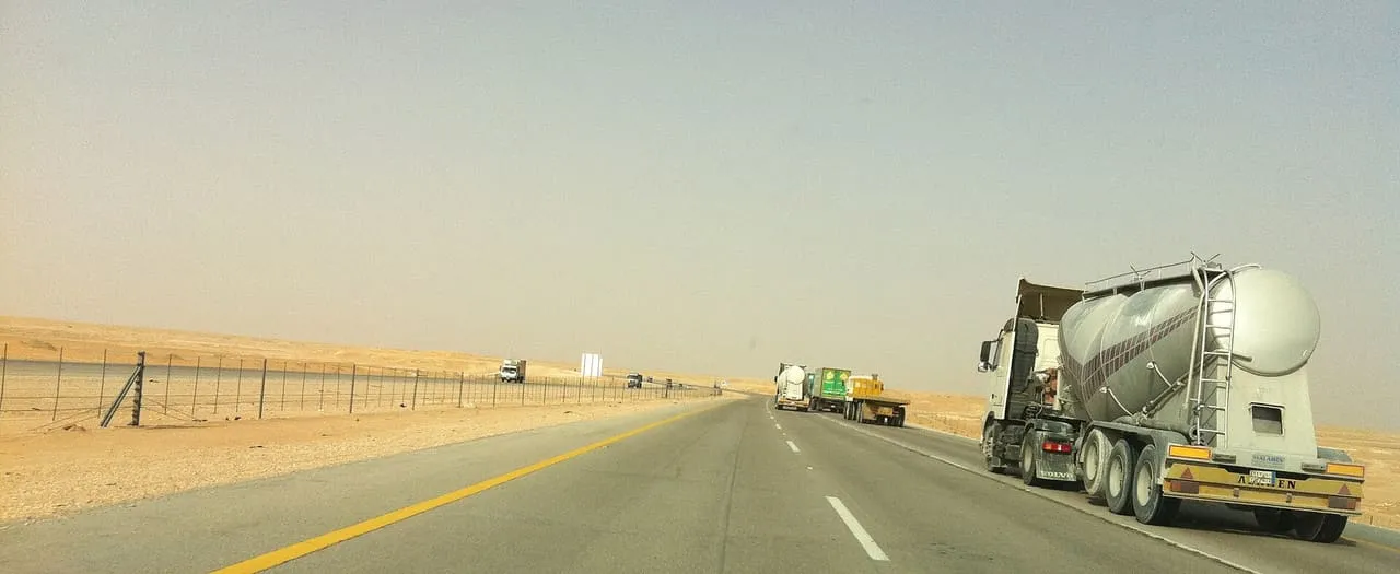 Trucks on the Dammam to Riyadh highway as it crosses open desert in Saudi Arabia