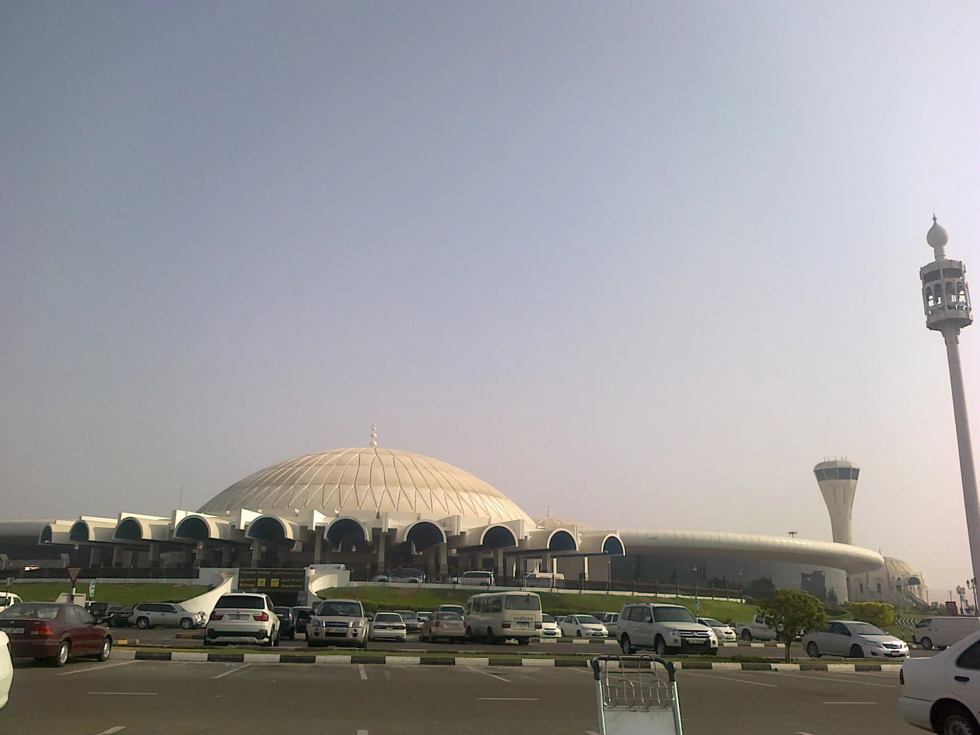 The domed passenger terminal and control tower at Sharjah International Airport, seen from the car park
