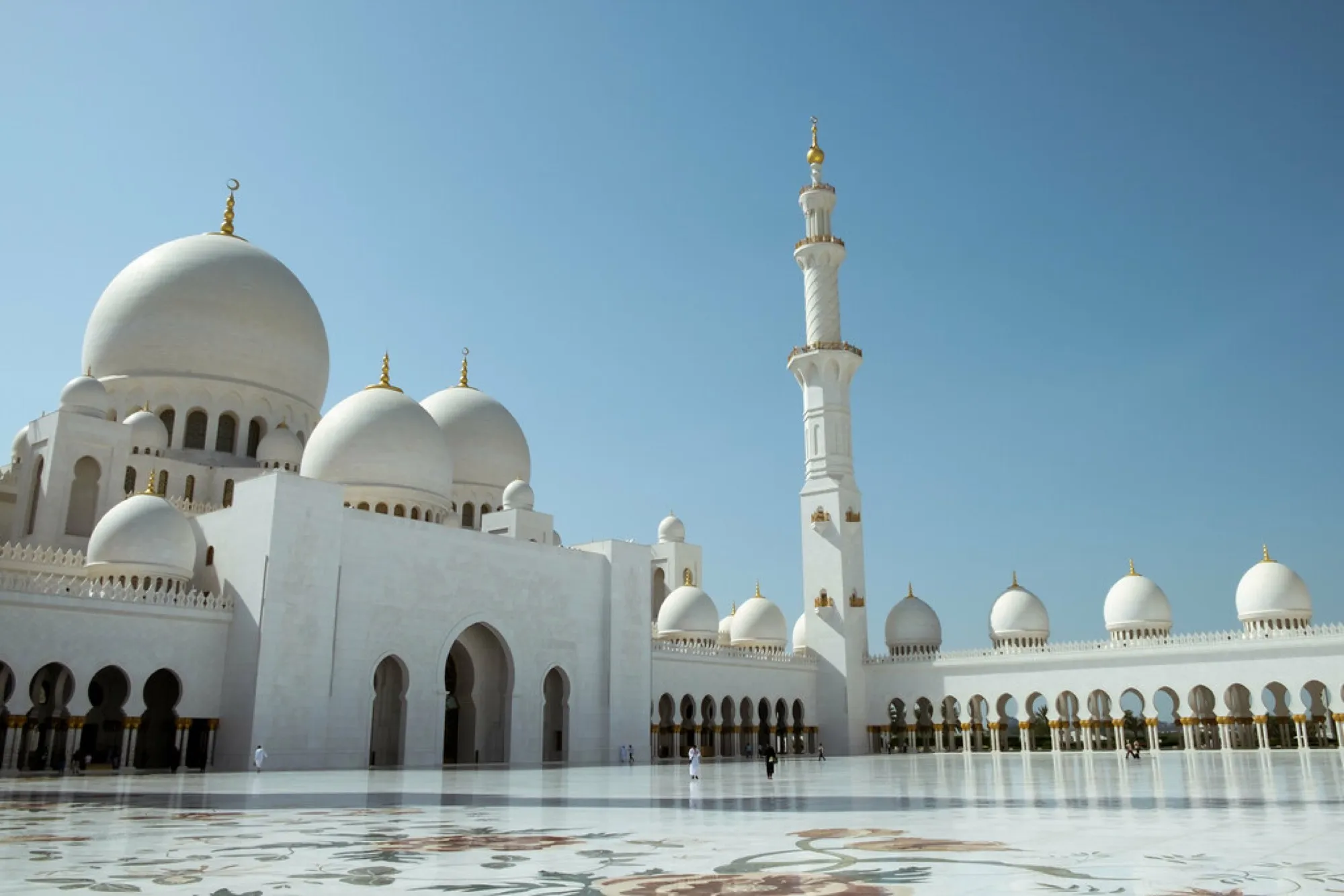 The white domes, minaret and marble courtyard of the Sheikh Zayed Grand Mosque in Abu Dhabi