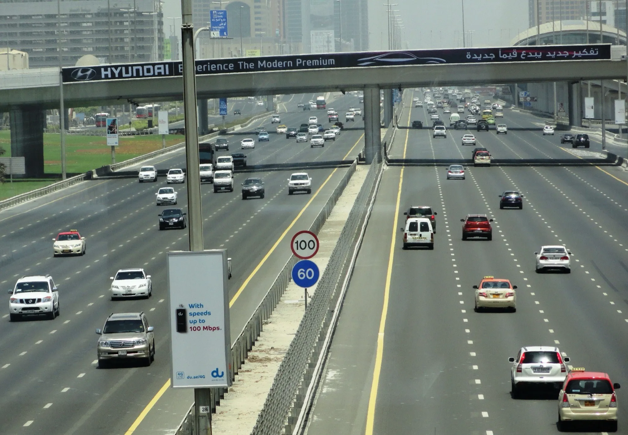 Traffic on Sheikh Zayed Road in Dubai, below signs for the 100 and 60 km/h speed limits
