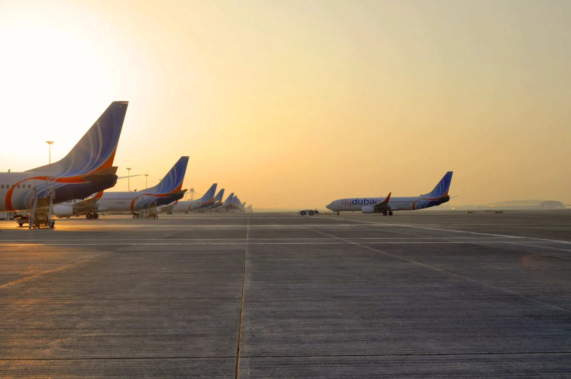 A line of flydubai Boeing 737s on the Terminal 2 ramp at Dubai International at sunrise
