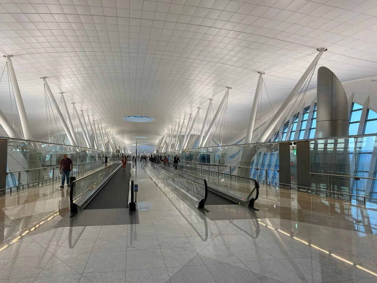 Moving walkways along a glass-walled pier in Terminal A at Zayed International Airport
