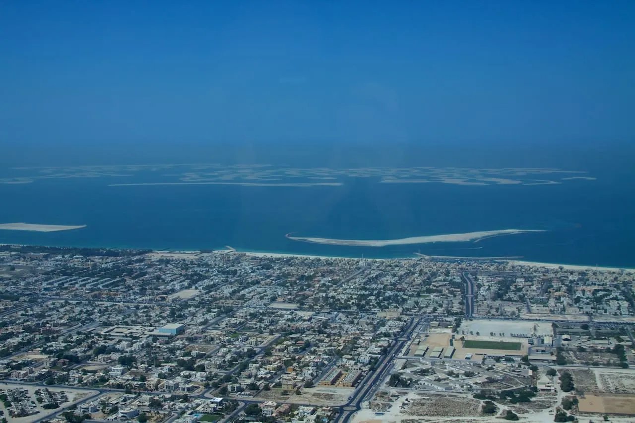 The World islands offshore from Dubai, seen from the air over low-rise neighbourhoods on the coast