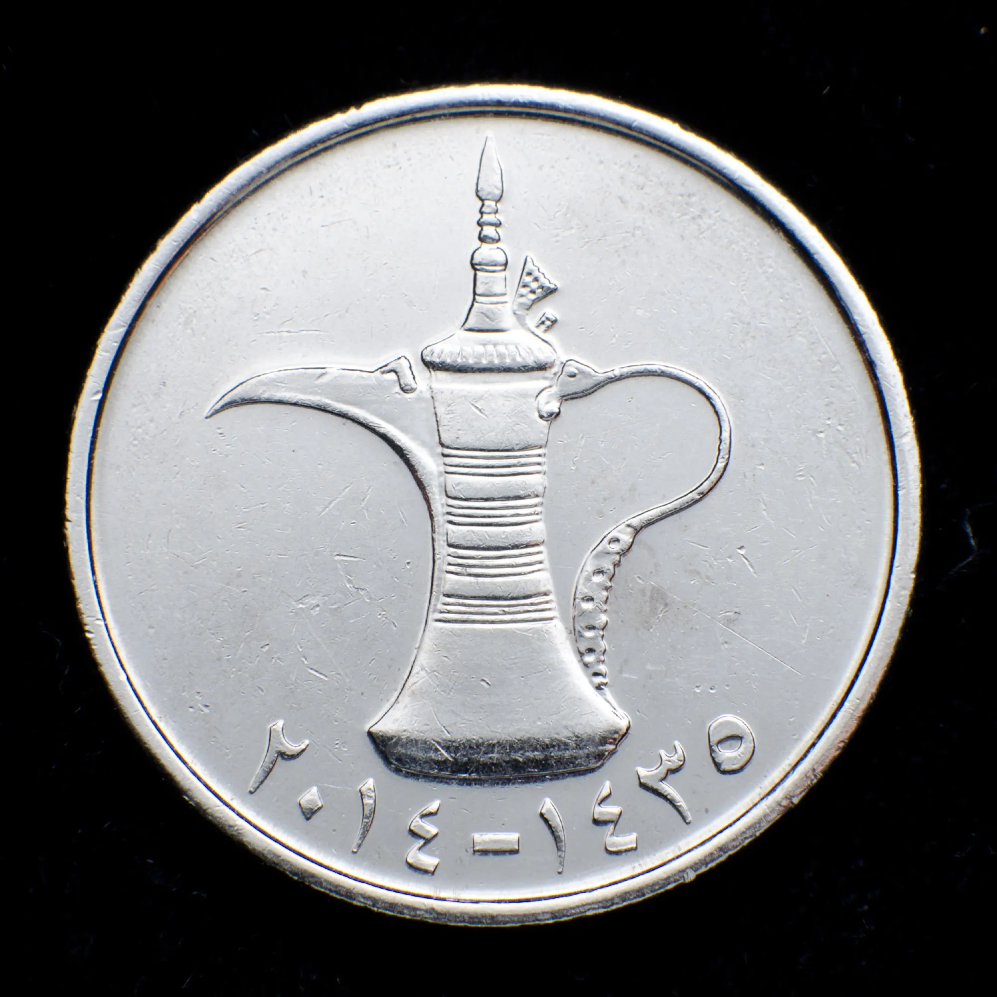 A UAE 1 dirham coin showing a dallah coffee pot