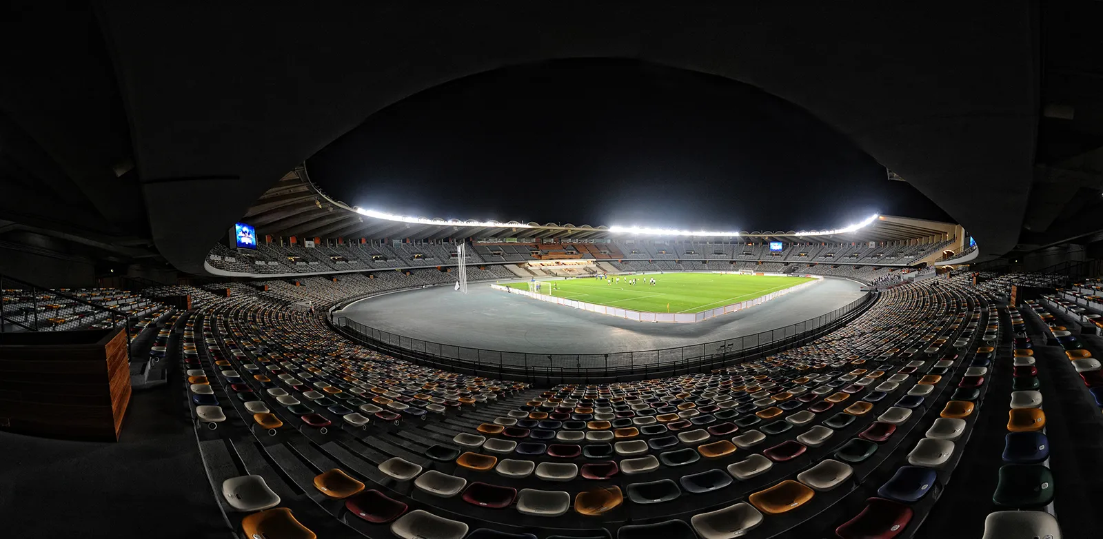 The curved grandstands of Zayed Sports City Stadium in Abu Dhabi seen from the pitch